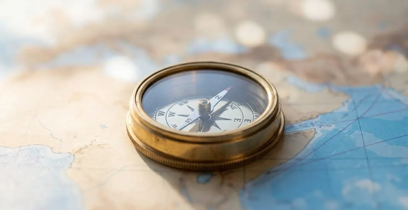 Gros plan artistique sur une boussole posée sur une carte de navigation méditerranéenne floue avec effet bokeh